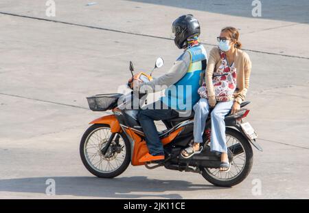 SAMUT PRAKAN, THAILAND, APR 15 2022, Ein Taxifahrer auf einem Motorrad fährt mit einer Frau. Stockfoto