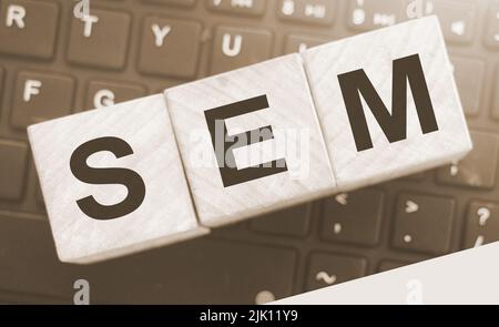SEM Search Engine Marketing auf einem hölzernen Würfel geschrieben, der auf Computertastatur gesetzt wird. Optimierung Online Business Technologie Konzept Stockfoto