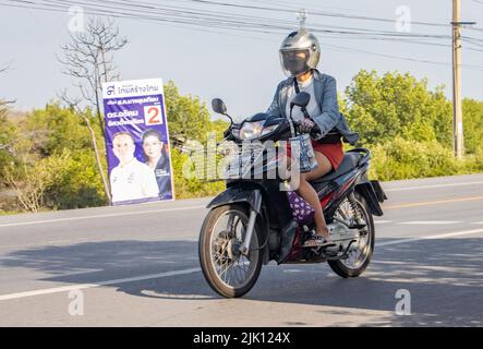 BANGKOK, THAILAND, APR 29 2022, Eine Frau mit Helm und Gesichtsmaske fährt ein Motorrad Stockfoto