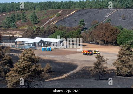 Hankley Common Wildfire, Surrey, England, Großbritannien. Fotografiert 5 Tage nach dem Großbrand, der am 24.. Juli 2022 ausbricht, und wurde vom Surrey Fire & Rescue Service zu einem Großschaden erklärt. Dies war das dritte einer Reihe von Bränden, die während des heißen, trockenen Wetters im Juli dieses Jahres üblich waren. Eine Fläche von 50 oder mehr Hektar Heide, ein wertvoller Lebensraum für bodenbrütende Vögel und seltene Reptilien, wurde zerstört. Die Feuerwehr überwacht weiterhin den Standort und dämpft alle Hotspots. Die Ursache des Feuers bleibt unbekannt. Stockfoto