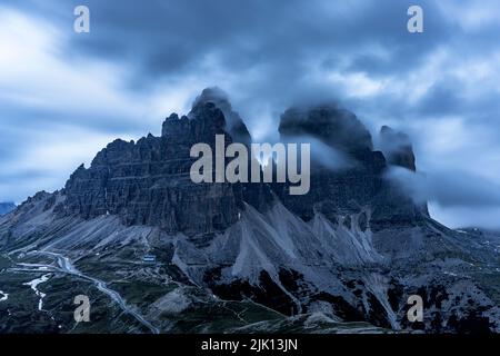 Wolken in der Abenddämmerung im nebligen Himmel über den Gipfeln der drei Zinnen von Lavaredo, Dolomiten, Südtirol, Italien, Europa Stockfoto