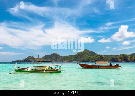 Outrigger Kanu- und Ausflugsboot vor Mahoro Island, Pahepa Island Beyond, Mahoro, Siau, Sangihe Archipel, Nord-Sulawesi, Indonesien Stockfoto