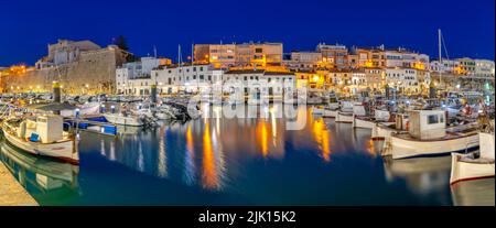 Blick auf Boote in der Marina, die in der Abenddämmerung von weiß getünchten Gebäuden überblickt werden, Ciutadella, Menorca, Balearen, Spanien, Mittelmeer, Europa Stockfoto