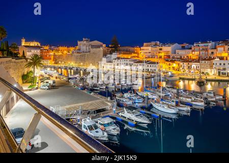 Blick auf Boote in der Marina, die in der Abenddämmerung von weiß getünchten Gebäuden überblickt werden, Ciutadella, Menorca, Balearen, Spanien, Mittelmeer, Europa Stockfoto