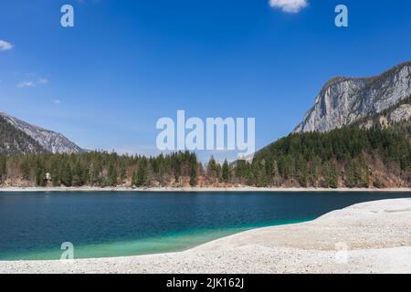 Der blaue Himmel spiegelt sich im smaragdmineralisierten Wasser des Tovel-Sees hoch in den Bergen, Ville d'Anaunia, Trentino, Italien Stockfoto