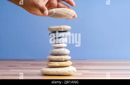Handgestapelte Kieselsteine, um eine Sanduhr als Symbol für Zeitmanagement zu Formen. Konzept der Meditation, verlangsamen und Kontrolle der Zeit. Stockfoto