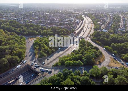 Kreisverkehr am Wasserwerk in Walthamstow. Ein großer Kreisverkehr mit der zweispurigen Straße A406, die in der Morgensonne durch den Wald führt Stockfoto