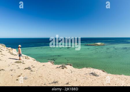 Eine Dame schaut auf das wunderschöne Wasser von Eagle Bluff, Denham, Shark Bay, Westaustralien Stockfoto