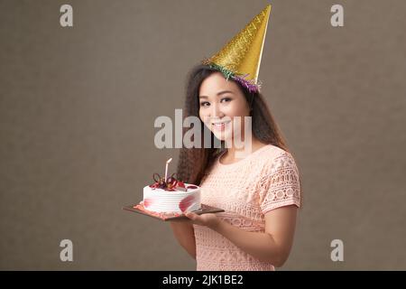 Hübsche Frau in Partykuchen zum Geburtstag Stockfoto