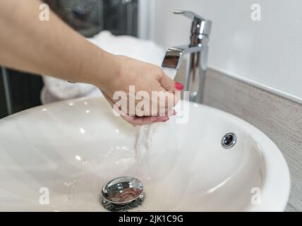 Frau, die sich in einem Hotelbadezimmer die Hände wusch. Spanien. Stockfoto