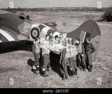 Eine Pilotbesprechung zum Aufzug eines Hawker Tempest Mark V, „JF-M“ in Newchurch, Kent, vor einem Sweep über das Caen-Gebiet. Die Hawker Tempest war ein britisches Kampfflugzeug, das von der Royal Air Force (RAF) ab 1944 im Zweiten Weltkrieg eingesetzt wurde. Es war das schnellste einmotorige Propellerflugzeug des Krieges in geringer Höhe. Es führte Low-Level-Abfangen durch, insbesondere gegen die Bedrohung durch die fliegende Bombe V-1, und Bodenangriffe auf die Eisenbahninfrastruktur in Deutschland und Flugzeuge der Luftwaffe am Boden Stockfoto