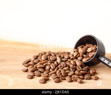 Kaffeebohnen werden aus dem Messlöffel verschüttet Stockfoto