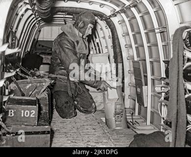 Einer der Luftbesatzungen eines Armstrong Whitworth Whitley Mark V einer Abteilung der RAF-Staffel der 102. Staffel in Villeneuve/Vertus, Frankreich, demonstrierte, wie Propagandaflugzeuge durch die Fackelrutsche auf Flugblatt-Fallbeispielen geworfen wurden. Der Armstrong Whitworth Whitley war einer von drei britischen zweimotorigen mittleren Bombertypen an der Front, die bei Ausbruch des Zweiten Weltkriegs bei der Royal Air Force im Einsatz waren und an dem ersten Bombenangriff der RAF auf deutsches Gebiet teilnahmen. Sie blieb bis zur Einführung von viermotorigen „Schweren“ ein integraler Bestandteil der frühen britischen Bomberoffensive. Stockfoto