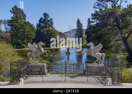 Irland, County Wicklow, Enniskerry, Powerscourt Estate House and Gardens, die Geflügelten Pferde am Triton Lake mit Springbrunnen, der im Hintergrund in die Luft schießt. Stockfoto