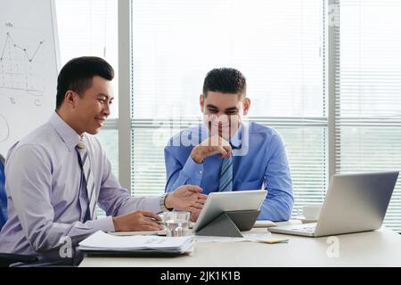 Fröhliche Geschäftsleute, die sich in einem modernen Büro treffen Stockfoto