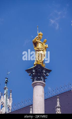 München, Deutschland - 6. Juli 2022: Die marianische Säule, gekrönt von einer vergoldeten Bronzestatue der Jungfrau Maria. Die goldene Statue oder Skulptur mit einem klaren BL Stockfoto