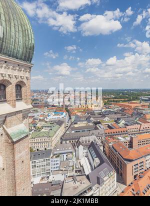 München, 6. Juli 2022: Blick auf die Skyline von München, vorbei an einem der beiden Türme des Münchner Doms, auch Frauenkirche genannt. Das Blau Stockfoto