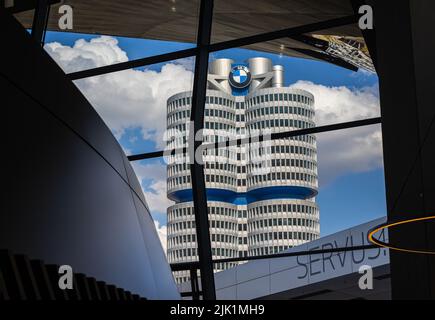 München, 6. Juli 2022: Der Hauptsitz der bayrischen Motorenwerke durch die Fenster der BMW-Welt in der Nähe des Olympiaparks. Das Gebäude Stockfoto