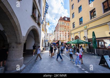 München, Deutschland - 6. Juli 2022: Die Königliche Brauerei in München, das Münchener Hofbräuhaus am Platzl. Ein muss für Touristen. Die bayerische Flagge und das HB-Logo Stockfoto