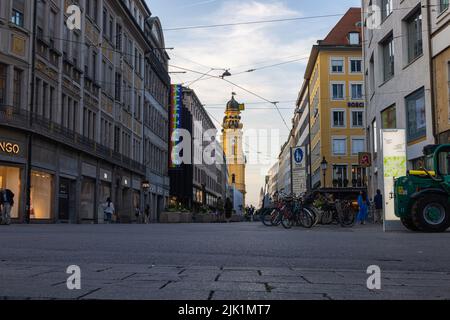 München, Deutschland - 6. Juli 2022: Blick auf die Theatinerstraße mit Blick auf die Theatinerkirche bei Sonnenuntergang. Der Kirchturm oder Glockenturm mit i Stockfoto