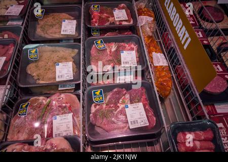 Fossano, Italien - 29. Juli 2022: Fertig zubereitete, gewürzte Steaks in Plastikvitrinen in Kühltheke im italienischen Eurospin-Supermarkt. Tex: Vorbereitung Stockfoto