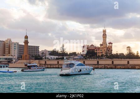 Montazah Blick auf den Strand, Montazah Palast und Leuchtturm Turm sind unter bunten bewölkten Himmel, Alexandria, Ägypten Stockfoto