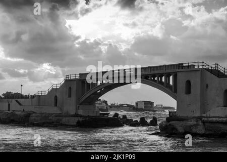 Montazah-Brücke unter bewölktem Himmel, Alexandria, Ägypten. Schwarzweiß-Foto Stockfoto