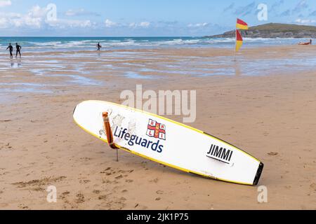 Ein RNLI Life Saving Surfboard, das für einen Notfall am Fistral Beach in Newquay in Cornwall in England in Großbritannien aufgestellt wurde. Stockfoto