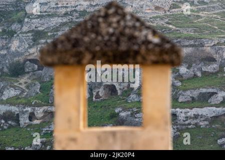 Blick auf Höhlenhäuser in Mdera, gesehen durch einen Kamin, Sassi di Miera in Italien Stockfoto