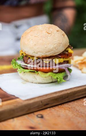 Vegetarischer Hamburger mit Ei, Tomaten, Salat, Zwiebeln und Pilzen auf einem Holzbrett Stockfoto