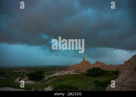 An einem Sommerabend rollt ein Gewitter aus dem Westen über die Landschaft des Badlands National Park in South Dakota. Stockfoto