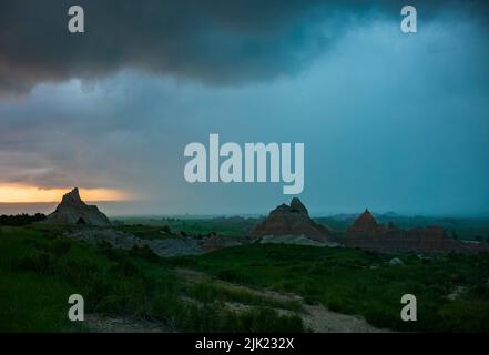 An einem Sommerabend rollt ein Gewitter aus dem Westen über die Landschaft des Badlands National Park in South Dakota. Stockfoto