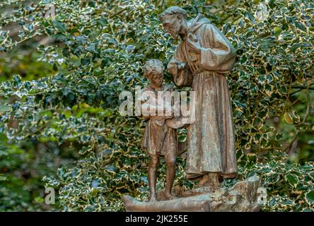 Bronzestatue des Heiligen Franziskus mit Kind an dem Convento Eremo Delle Carceri, Assisi, Umbrien, Italien Stockfoto