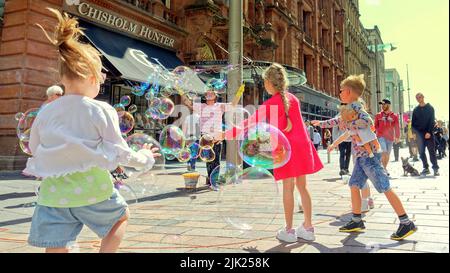 Glasgow, Schottland, Großbritannien, Juli 29. 2022. UK Weather: Ein polnischer Blasenbläser trat auf der Style Mile of Scotland , Buchanan Street auf, sehr zur Freude der Käufer und Kinder, als er in Glasgow auf dem Weg zum Edinburgh Festival, das nächste Woche beginnt, Halt machte. Credit Gerard Ferry/Alamy Live News Stockfoto