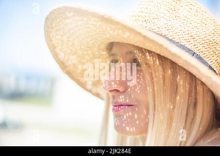 Schöne blonde Frau in einem Strohhut. Stockfoto