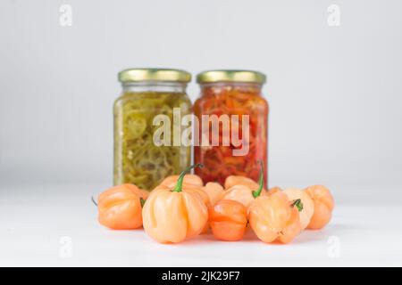 Ein Scotch-Haubenpfeffer mit Stiel auf weißem Hintergrund, frischer Pfeffer, Orangenkorallenpfeffer, nigerischem Scotch-Haubenpfeffer Stockfoto