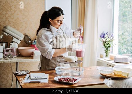 Konditor kleines Unternehmen, arabischen Konditor Koch machen Herz Form Spiegel Glaze Mousse Kuchen Stockfoto