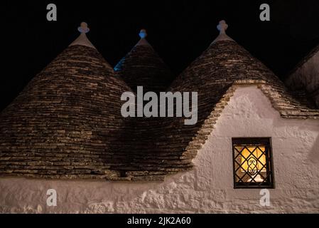 Malerische verlassene Straße im Trulli-Viertel von Alberobello bei Nacht, Italien Stockfoto