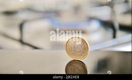 Eine Euro-Münze auf dem Hintergrund einer Gasflamme, die die Bezahlung von Waren symbolisiert Stockfoto