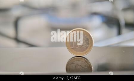 Eine Euro-Münze auf dem Hintergrund einer Gasflamme, die die Bezahlung von Waren symbolisiert Stockfoto