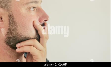 Ein nachdenklicher junger Mann, Nahaufnahme auf weißem Hintergrund Stockfoto