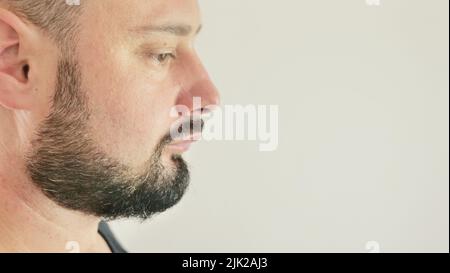 Profil eines denkenden jungen Mannes anzeigen. Nahaufnahme auf weißem Hintergrund Stockfoto