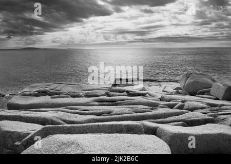 Ein künstlerisches s&w-Foto der verwitterten Granitfelsen mit Blick auf den Sonnenaufgang am Atlantischen Ozean entlang der Küste des Acadia National Park, Mount Stockfoto