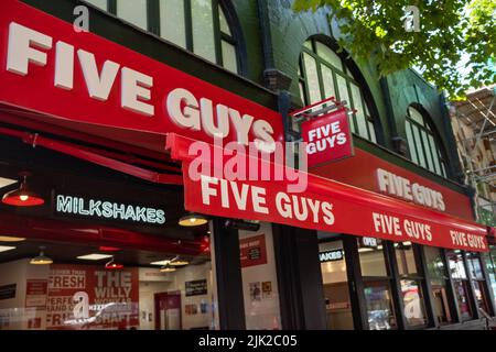 London, 2022. Juli: Fünf Jungs in Chiswick, West-London. Eine amerikanische Fast-Food-Restaurantkette Stockfoto