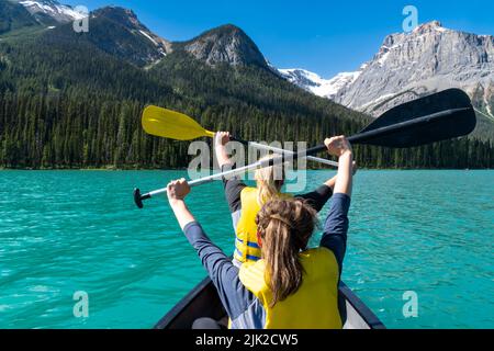Zwei Erwachsene Frauen paddeln auf einem Kanu auf dem Emerald Lake im Yoho National Park in British Columbia, Kanada