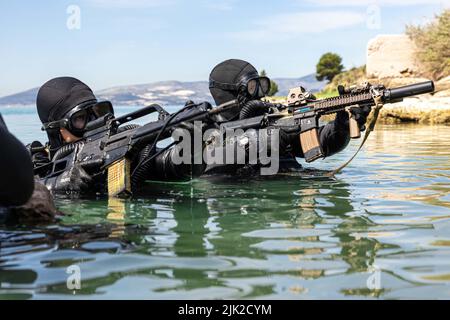 Ein Mitglied der kroatischen Zapovjedništvo Specialjalnih Snaga (ZSS) und ein Mitglied der U.S. Naval Special Warfare Task Unit Europe (NSWTU-E) führen am 15. April 2022 in Split, Kroatien, eine Übung über dem Strand (OTB) durch. Für die kroatische ZSS ist Joint Combined Exchange Training oder JCET mit Partnerländern keine Seltenheit. Die ZSS wurde 2000 als Spezialeinsatzbataillon gegründet und hat seitdem an mehreren Operationen teilgenommen, darunter auch an Stationen in Afghanistan als Teil der Internationalen Sicherheitsunterstützungstruppe (ISAF) der NATO. (USA Armeefoto von Sgt. Patrik Orcutt) Stockfoto