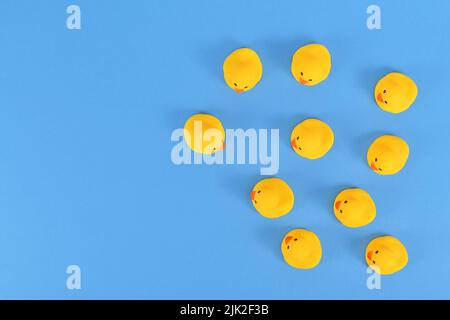 Draufsicht auf viele gelbe Gummienten auf blauem Hintergrund mit Kopierraum Stockfoto