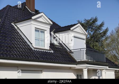 Freistehendes Haus mit Giebelgächern auf schwarzem Dach Stockfoto