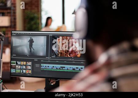 Junge freiberufliche Übersetzerin bearbeitet Filmmaterial auf Software und arbeitet an der Bearbeitung von Videomontagen mit Farbkorrektur und Audioeffekten. Ton- und Filmproduktion, kreativer Film am Computer. Stockfoto