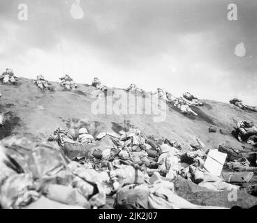 Marines der 5. Division schlagen sich einen Hang hoch am Red Beach No. 1 in Richtung Surbachi Yama, während der Rauch der Schlacht um sie herabdriftet. Stockfoto